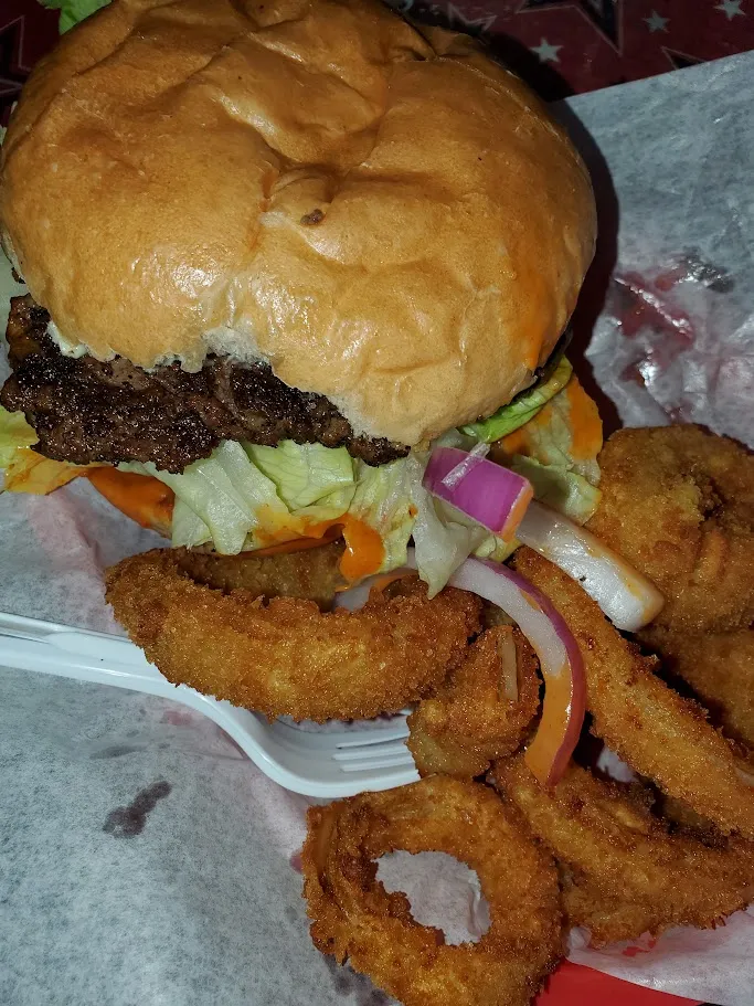 Smoked beef burger with onion rings at Harper's BBQ near Garden Oaks